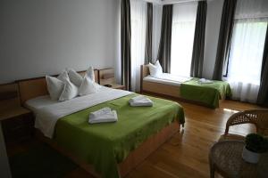 um quarto de hotel com duas camas com lençóis verdes em Egreta By Hoxton em Uzlina