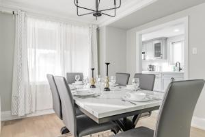 uma sala de jantar branca com uma mesa e cadeiras em Victoria Park Suite em Toronto