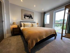 a bedroom with a large bed and a large window at 6 Breakwaters in Sandown
