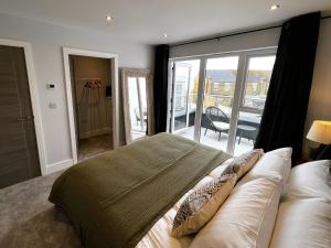 a bedroom with a large bed and a balcony at 6 Breakwaters in Sandown