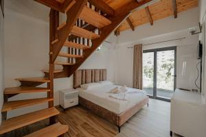 1 dormitorio con 1 cama y escalera de madera en Hotel Take, en Borsh