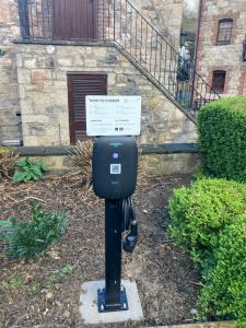 a parking meter with a sign on it in front of a building at The Old Mill Holiday Cottages, Nr Mold in Mold