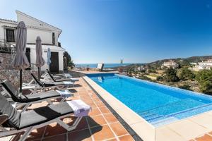 a villa with a swimming pool with a view of the ocean at villa larwik frigiliana in Frigiliana