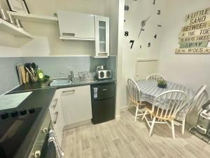 a small kitchen with a table and a dining room at Homely Apartment in the Heart of Town Centre - Sleeps 6 in Bournemouth