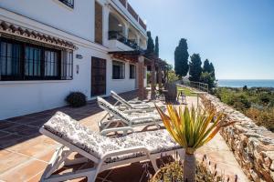 a row of chaise lounge chairs on a patio at villa larwik frigiliana in Frigiliana