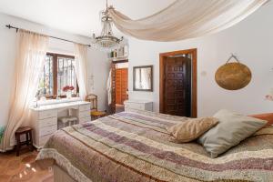 a bedroom with a bed and a desk and a sink at villa larwik frigiliana in Frigiliana +56 photos
