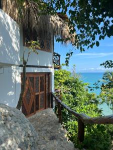 un edificio con una puerta de madera y el océano en Casa en la Playa Morro Paraiso, en Palomino