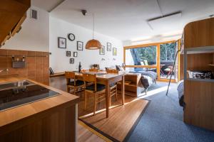 a kitchen and living room with a table and chairs at Riversound in Kranjska Gora