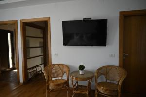 um quarto com uma mesa e cadeiras e uma televisão na parede em Egreta By Hoxton em Uzlina