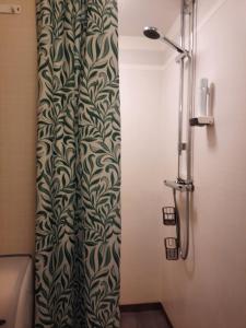 y baño con ducha y cortina de ducha. en KvarnDammens Bed & Breakfast en Vetlanda