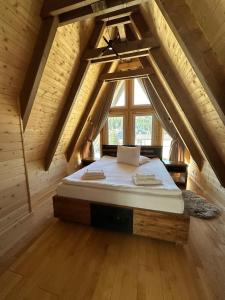 1 dormitorio con 1 cama grande en el ático en Cabana Maria Comandau, en Comandău