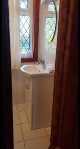 ein Bad mit einem Waschbecken und einem Fenster in der Unterkunft Stay With Jack in Limerick