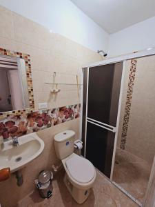 Un baño con inodoro, lavabo y ducha. en comodo apartamento central, en Buga