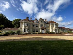 a large house with a large lawn in front of it at 6 Shanklin Manor - family friendly apartment in Shanklin Old Village in Shanklin