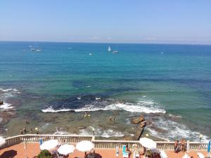 uma vista para a praia com um barco na água em Residence Mediterraneo - Baia del Quercetano em Castiglioncello