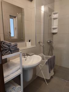 een witte badkamer met een wastafel en een spiegel bij LA88 Sweet Home in San Ġwann
