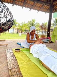 una mujer sentada en una manta en el suelo en Hotel Real Comandatuba en Ilha de Comandatuba