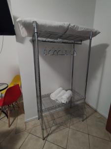 ein Metallregal mit Handtüchern auf dem Zimmer in der Unterkunft Pousada Indi in Ribeirão Preto