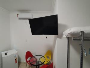 uma televisão de ecrã plano pendurada numa parede num quarto em Pousada Indi em Ribeirão Preto