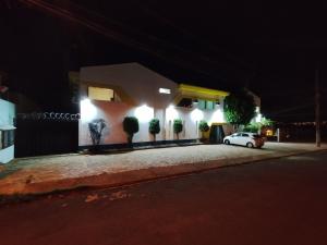 um carro branco estacionado em frente a uma casa à noite em Pousada Indi em Ribeirão Preto