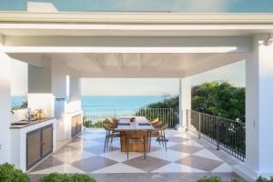 une terrasse avec une table et des chaises et l'océan dans l'établissement Luxury on the Beach, à Westbrook