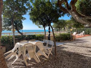 uma mesa e cadeiras com o oceano ao fundo em Residence Mediterraneo - Baia del Quercetano em Castiglioncello