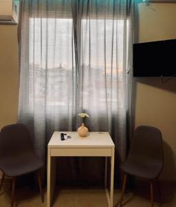 une table avec un vase sur elle à côté d'une fenêtre dans l'établissement Sunny apartment 1, à Serres