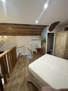 ナルボンヌにあるSuite a Mezzanine dans l'Église du Couventの白いベッドとウッドフロアのベッドルーム1室