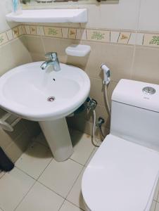 ein Badezimmer mit einem weißen WC und einem Waschbecken in der Unterkunft Master Room With Attached Washroom For You in Ajman 