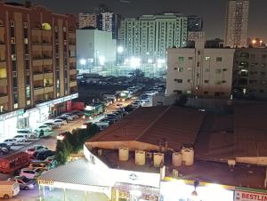uma vista de um parque de estacionamento numa cidade à noite em Master Room With Attached Washroom For You em Ajman