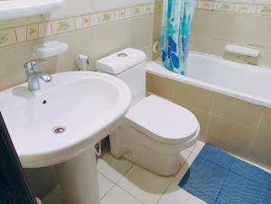 ein Badezimmer mit einem Waschbecken, einem WC und einer Badewanne in der Unterkunft Master Room With Attached Washroom For You in Ajman 