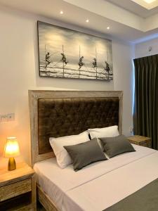 a bedroom with a bed with a painting on the wall at Ocean Breeze Sea Haven Luxury Apartments in Negombo