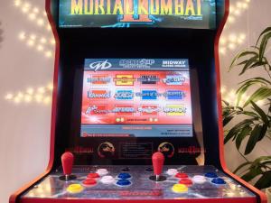 una máquina de videojuegos con kinemacista rojo en Leeds getaway with hot tub & gaming room, en Wakefield