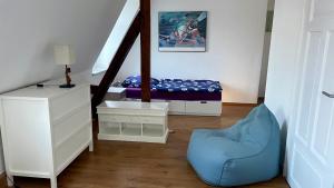 ein Schlafzimmer mit einem Bett und einem blauen Stuhl in der Unterkunft Dresden City in Dresden