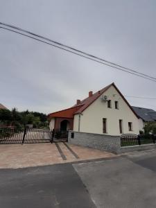 ein weißes Haus mit einem Zaun davor in der Unterkunft Noclegi Dobrzeń Wielki in Dobrzeń Wielki