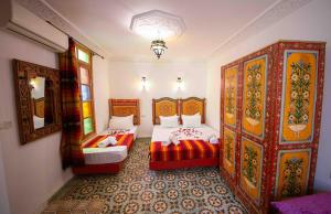1 dormitorio con 2 camas y espejo en Dar houda, en Fez