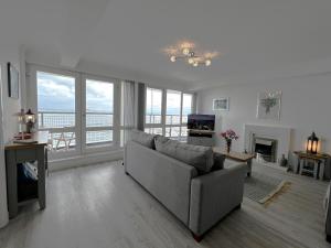 uma sala de estar com um sofá e vista para o oceano em Belle Vue em Sandown