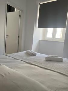 een slaapkamer met een bed met twee handdoeken erop bij PÉROLA DO BOCAGE - no coração de Setúbal in Setúbal