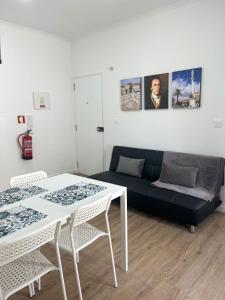 a living room with a white table and a couch at PÉROLA DO BOCAGE - no coração de Setúbal in Setúbal