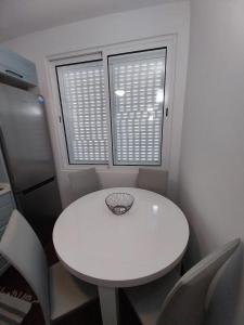 tavolo e sedie bianchi in una stanza con due finestre di Villa Supranee 1 a Câmara de Lobos