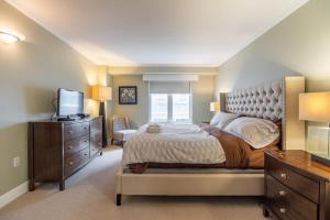 ein Schlafzimmer mit einem Bett, einer Kommode und einem TV in der Unterkunft Lovely Waterfront Apt #807 with AC in Halifax