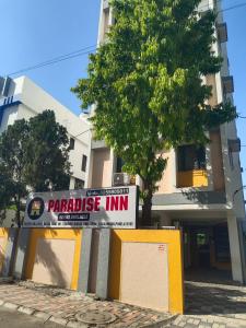 a sign that reads paradise inn in front of a building at Paradise inn in Alandi