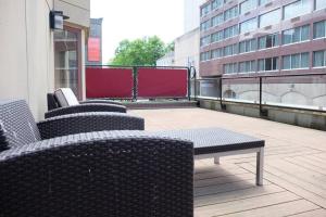 a balcony with chairs and a table on a building at Deluxe Downtown Apt #404 with AC in Halifax