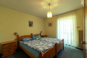 una camera da letto con un letto di legno e una finestra di Appartamenti Césa Col De Pin a Canazei