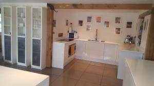 a kitchen with white cabinets and a sink at Prestwick Oak - 2 Kingsize Ensuite - Openplan Contemporary - Rural - Garden in Chiddingfold