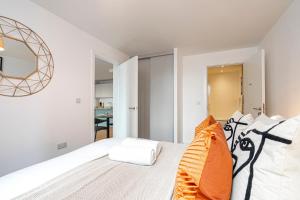 ein Schlafzimmer mit einem weißen Bett und einem orangefarbenen Kissen in der Unterkunft Monk Bridge Viaduct in Leeds