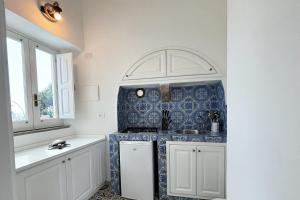 パナレーアにあるCasa Acquamarinaの青と白のタイルの壁のキッチン