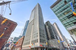 a tall building in the middle of a city at Modern 2-Bedroom Condo w Floor to Ceiling Windows in Toronto