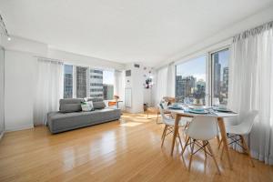 a living room with a couch and a table with chairs at Modern 2-Bedroom Condo w Floor to Ceiling Windows in Toronto