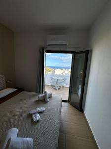 a bedroom with a bed and a view of the ocean at OMIROS HOTEL in Mesaria